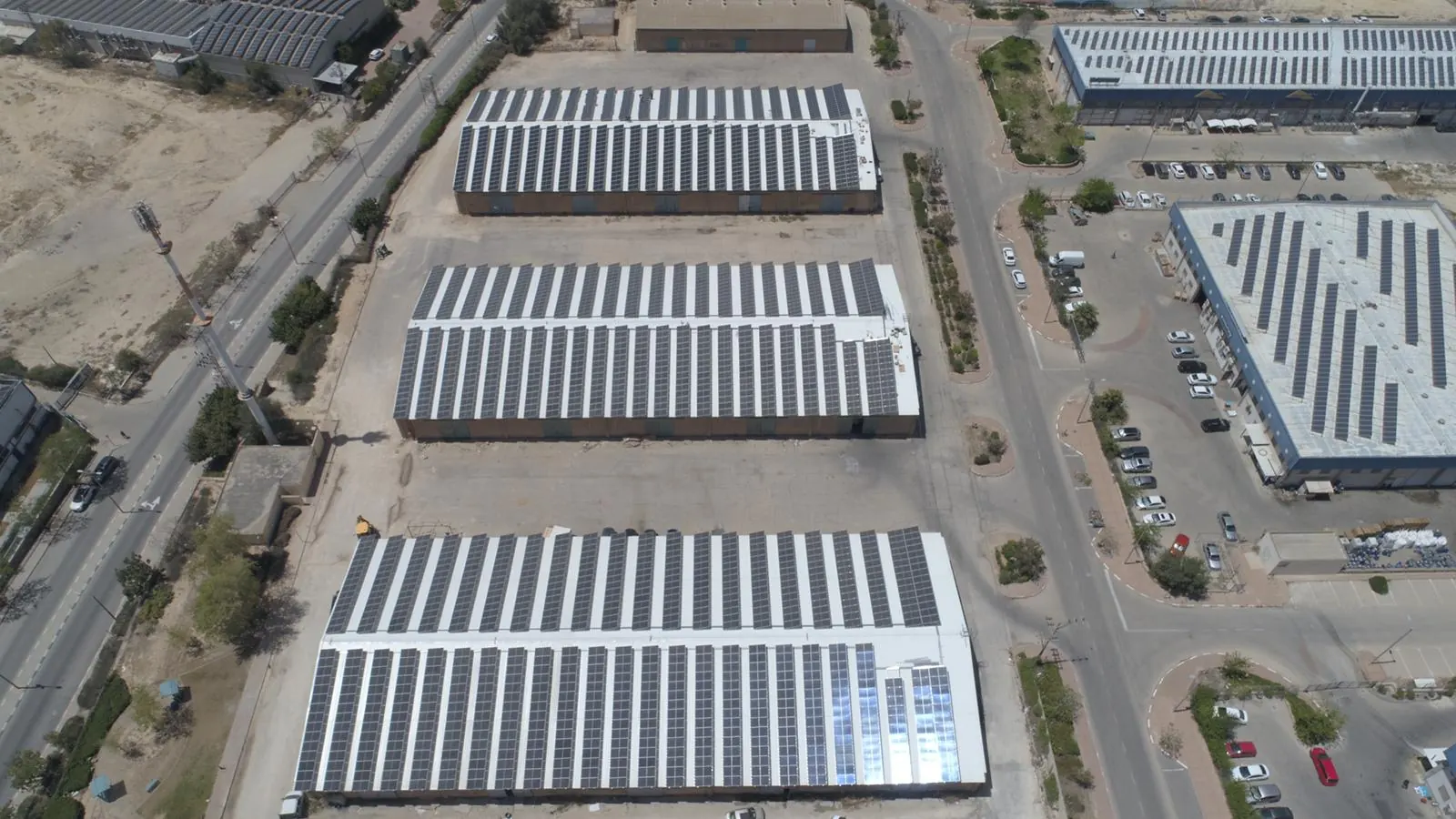 Tre capannoni vicini con impianti fotovoltaici sul tetto, visti dall’alto